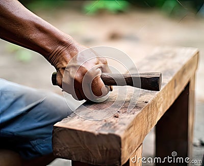 The carpenter is repairing the house. He makes nails using a hammer Stock Photo