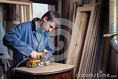 Carpenter restoring furniture with belt sander Stock Photo