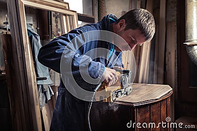 Carpenter restoring furniture with belt sander Stock Photo