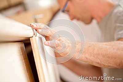 Carpenter's hand placing a board Stock Photo