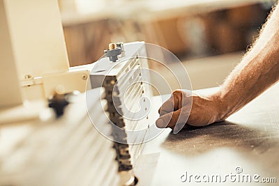 Carpenter's muscular hand working wooden furniture Stock Photo