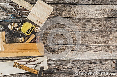 The carpenter tools on wooden bench, plane, chisel,mallet, tape measure, hammer, tongs, pliers, level, nails and a saw Stock Photo