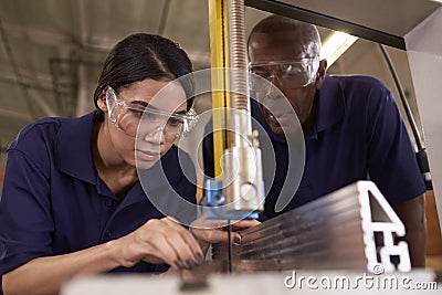 Carpenter Training Female Apprentice To Use Mechanized Saw Stock Photo