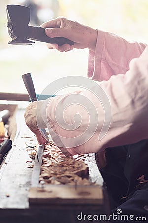 Carpenter uses carved chisels,Carved wood,Use the tool,Folk crafts,Use a hammer Stock Photo
