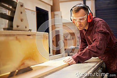 Carpenter Using Circular Saw In Carpentry Workshop Stock Photo