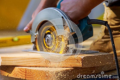 Carpenter using circular saw for cutting wooden boards with hand power tools. Stock Photo