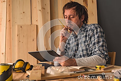 Carpenter using digital tablet in small business woodwork workshop Stock Photo