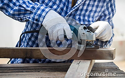 Carpenter using grinder on wood Stock Photo