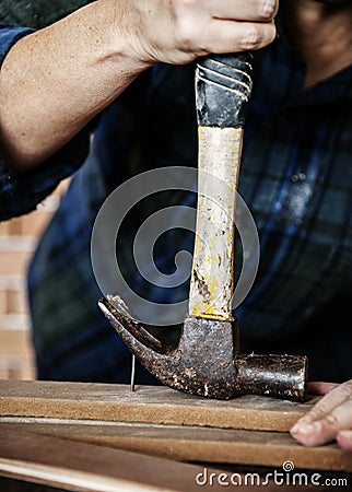 Carpenter using hammer pull a nail out from a wood Stock Photo