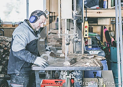 Carpenter using table saw for cutting wood at workshop - Woodworker working hard at home - Bricolage work concept - Soft focus one Stock Photo