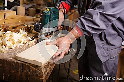 Carpenter at work with electric planer joinery Stock Photo