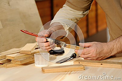 Carpenter at work gluing piece of wood Stock Photo