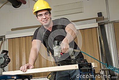 Carpenter at work on job using power tool Stock Photo