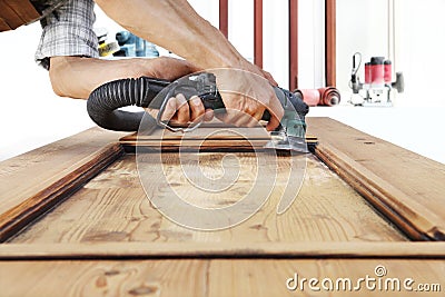 Carpenter work the wood with the sander Stock Photo
