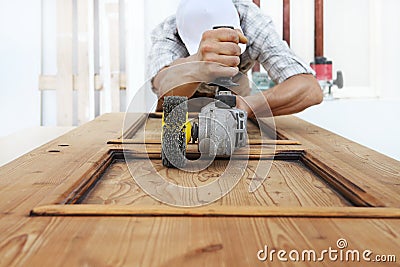 Carpenter work the wood with the sander grinding electric tools Stock Photo