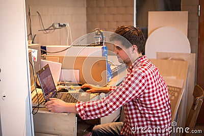 Carpenter worker prepares a computer program software for CNC ma Stock Photo