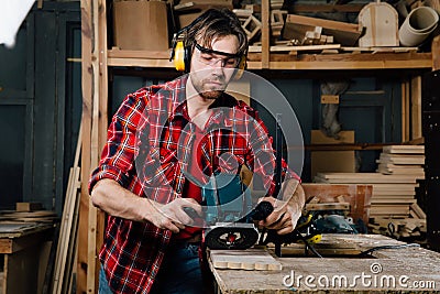 Carpenter working of manual hand milling machine in the carpentry workshop. joiner. Stock Photo