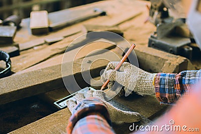 Carpenter is working in a woodworking office.caucasion white Carpenter using tape measure to measure distance and marking with Stock Photo