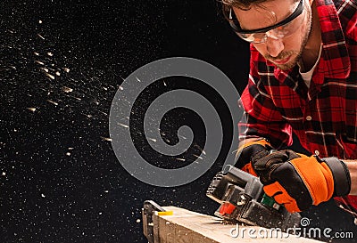 Carpenter works with electrical planer Stock Photo