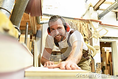 carpenter works in a joinery - workshop for woodworking and sawing Stock Photo