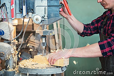 Carpenters with electric drill machine drilling wooden board Stock Photo