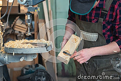 Carpenters with electric drill machine drilling wooden board Stock Photo