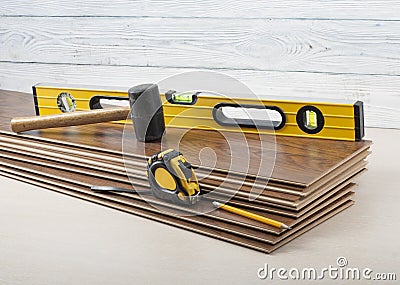 Carpentry concept.Different tools- level,tape-measure,rubber hammer on the new laminate flooring.Copy space for text. Stock Photo