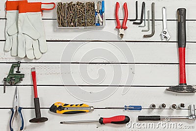 Carpentry tools lie evenly arranged on white wooden boards. Stock Photo