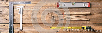 Carpentry. Measure tape, spirit level and rulers on wooden background, banner, copy space, top view Stock Photo