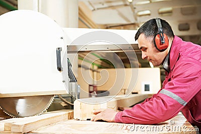 Carpentry worker cutting wood cross beam Stock Photo