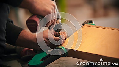 Carpentry - worker drills holes into the plywood indoors Stock Photo