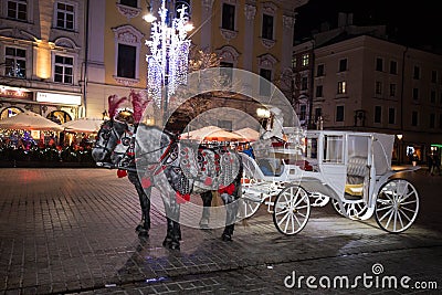 A carriage with horses. Christmas square. Krakow. Celebration. Night fair. Feast of approaching Editorial Stock Photo