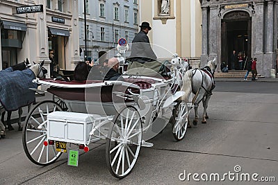 Carriage with horses, driver and tourists in Vienna on a sightseeing tour around the city Editorial Stock Photo