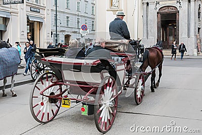 Carriage with horses, driver and tourists in Vienna on a sightseeing tour around the city Editorial Stock Photo