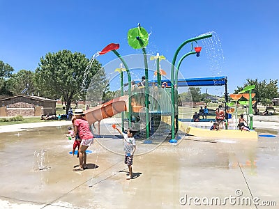 Happy multicultural kids and parent playing at splash park in Texas in post COVID-19 pandemic Editorial Stock Photo