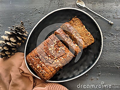 Carrot cake loaf made with oats and almonds, sliced on a black dish, top view. vegan, eggless cake. Healthy, diet, nutrition Stock Photo