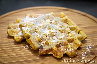 Carrot waffles with powdered sugar on a wooden boardPerfect healthy breakfast Stock Photo