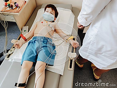 carrying out an electrocardiogram on the chest of a boy during the annual therapeutic examination. Diagnosis of heart Stock Photo