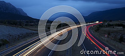 cars driving on the freeway with lights on at dusk Stock Photo