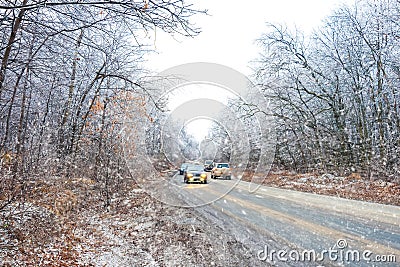 Cars move in winter snowy driving journey on forest road Stock Photo