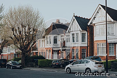 Cars parked in front of a row of Edwardian houses on a street in Palmers Green, London, UK Editorial Stock Photo