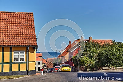 Cars parked on a steep street leading down to Baltic sea in Svaneke, Bornholm island, Denmark. Editorial Stock Photo