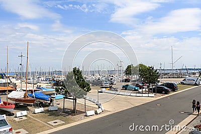 Cars parking and sailboats docked at the pier viewed from University of Kiel Sailing Center Editorial Stock Photo