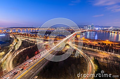 Cars passing in intersection, Han River and bridge at Night in Downtown Seoul, South Korea Stock Photo