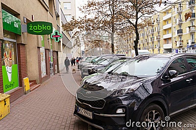 Cars stand in a parking lot on a city street near a cafe Zabka Editorial Stock Photo