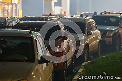 cars stuck in traffic jam at gas station at foggy night during supply crunch Stock Photo