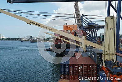 Container ship equipped with ship cranes during cargo operation loading and discharging by gantry cranes. Editorial Stock Photo