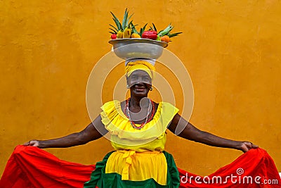 CARTAGENA DE INDIAS, COLOMBIA - July 27, 2017: Beautiful smiling woman wearing traditional costume sell fruits in the center of Ca Editorial Stock Photo