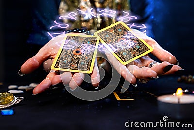 Cartomancy. The fortune teller holds out two Tarot cards on her palms. The zodiac circle is depicted above the hand with Stock Photo