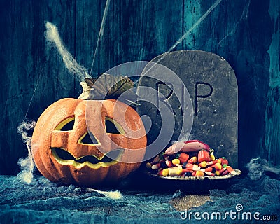 Carved pumpkin, gravestone and Halloween candies Stock Photo